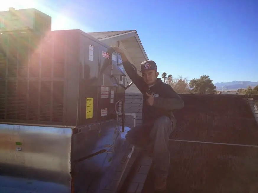 HVAC technician performing Heat Pump Repair on a rooftop unit in Arden Hills